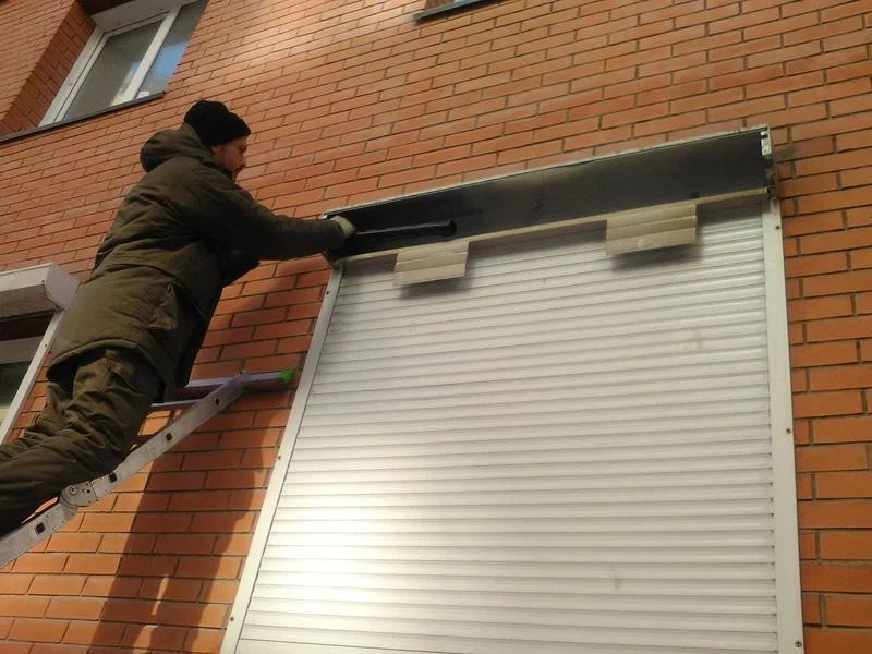 man repairing shutter