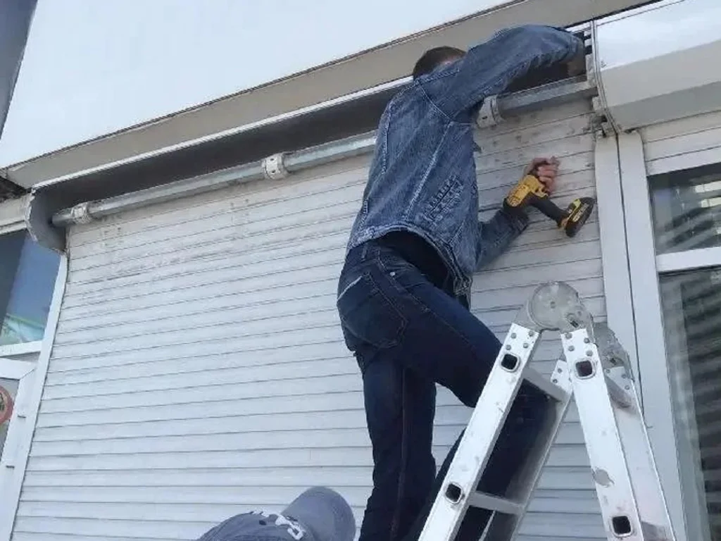 man repairing shutter